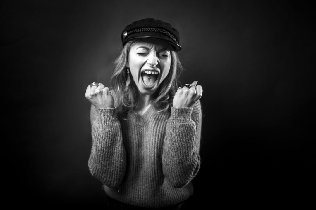 ragazza in bianco e nero che urla stringendo i pugni