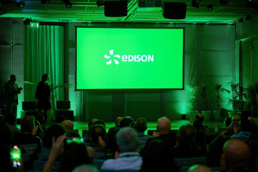 palcoscenico visto da dietro la platea con proiezione logo edison e luce verde,