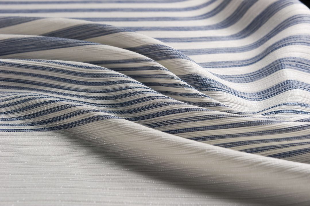 tessuto a con intrecciatura a linee con strisce irregolari blu appoggiato creando onde curve morbide ed eleganti